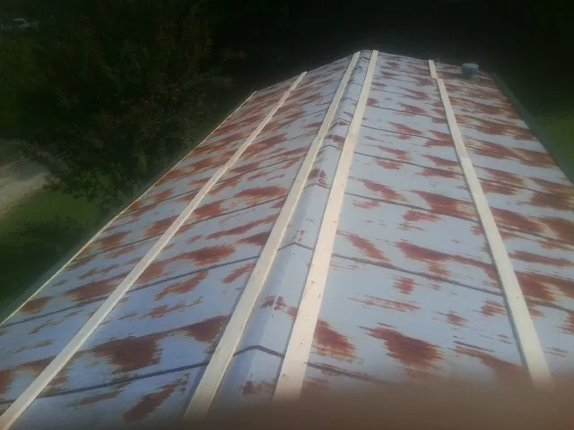 Rusted metal roof panels with new wood purlins before replacement — Storm Damage Roof Repair in Hopkinton by Roofing Brothers