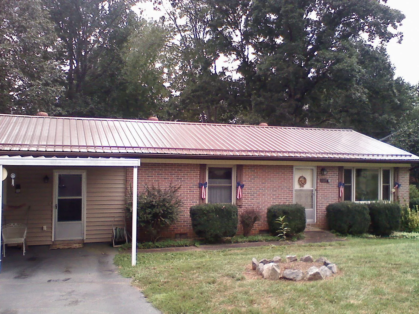 Bronze metal roof and carport on a brick ranch home — Roof Repair work by our crew in Hopkinton