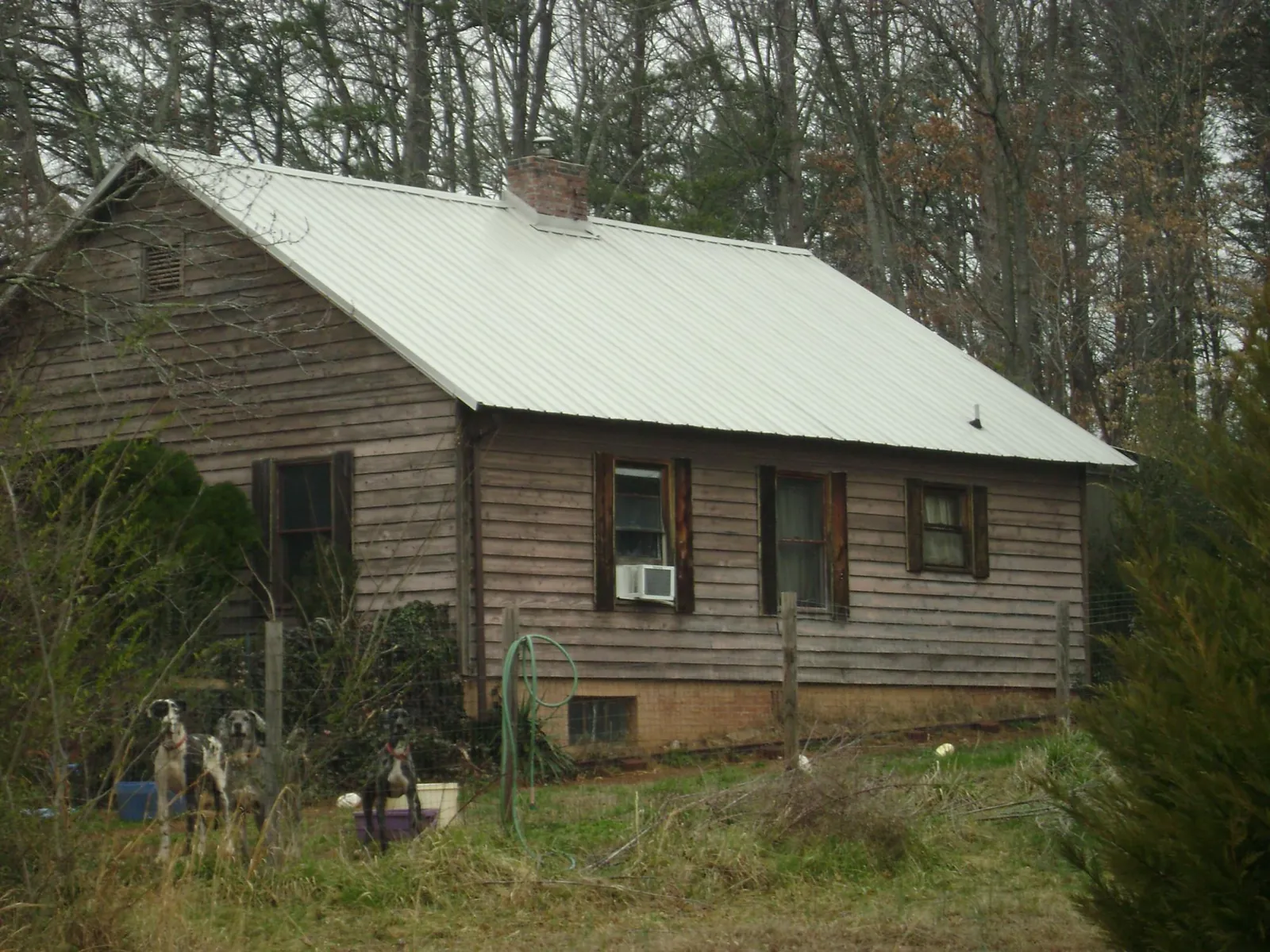 White metal roof on an old wood sided farmhouse, from a Metal Roof Installation job in Hopkinton